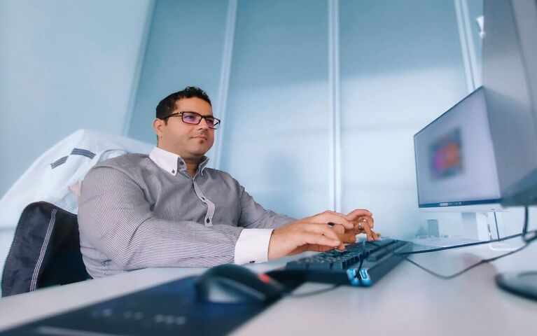 Mitarbeiter sitzt in seinem Büro am arbeiten. 